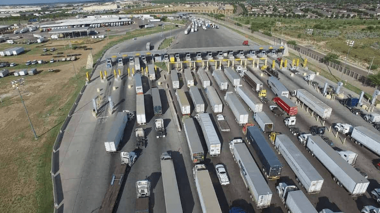 A large group of trucks parked at a toll booth, symbolizing Mexico's economic growth and transportation infrastructure.